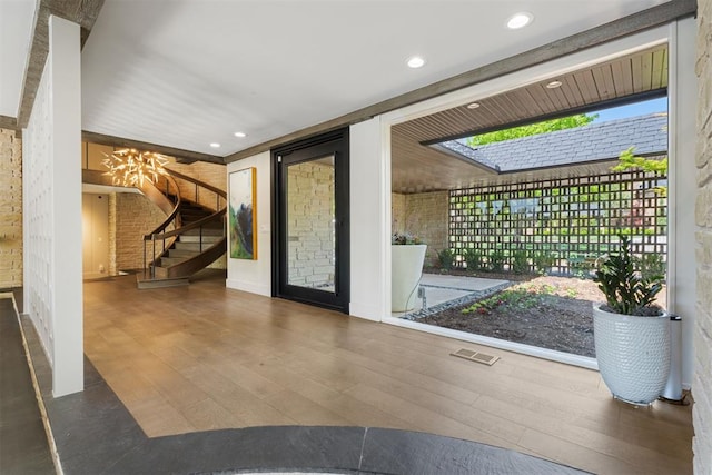 foyer with visible vents, stairs, wood finished floors, an inviting chandelier, and recessed lighting