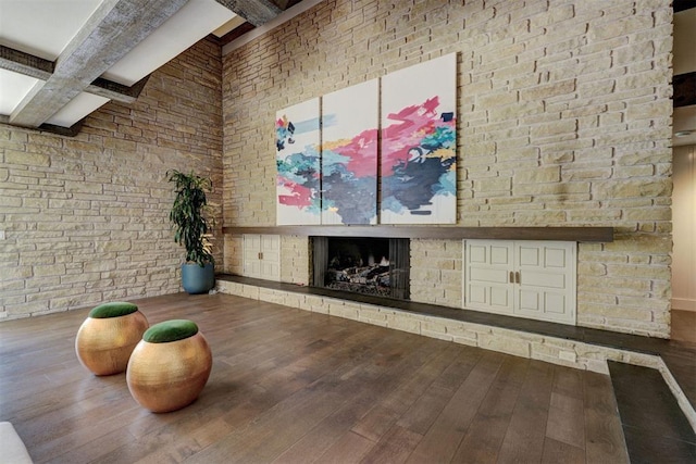 workout area featuring a fireplace with raised hearth and hardwood / wood-style flooring