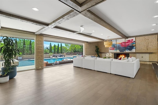 living area with brick wall, plenty of natural light, and wood finished floors