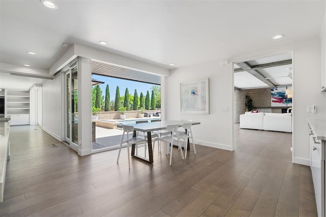dining space with dark wood finished floors, baseboards, and recessed lighting