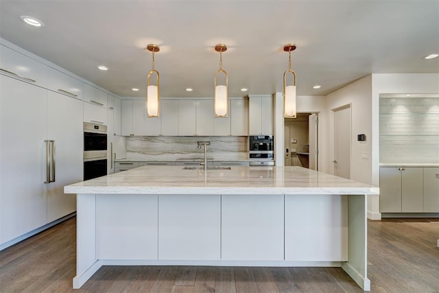 kitchen with backsplash, a spacious island, double oven, and dark wood-type flooring