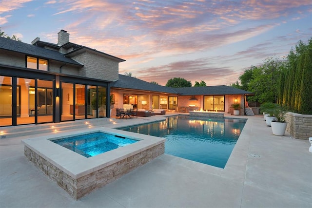 pool at dusk featuring a patio, an in ground hot tub, an outdoor living space, and an outdoor pool