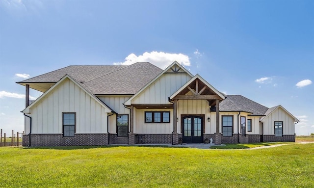 view of front of home with a shingled roof, board and batten siding, french doors, and a front lawn