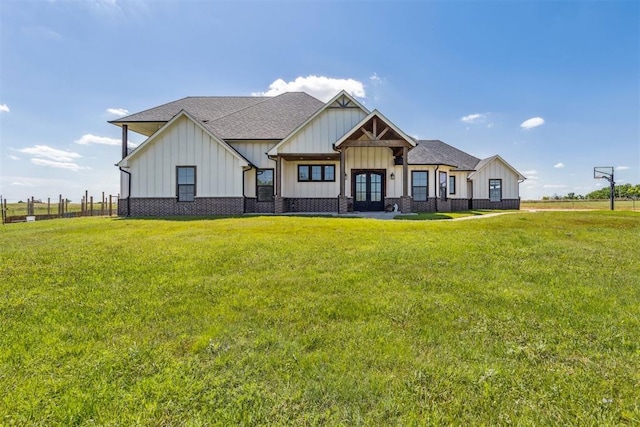 view of front of home featuring roof with shingles, a front lawn, french doors, and board and batten siding