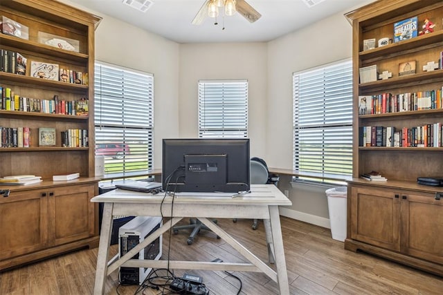 home office with ceiling fan, light wood-style flooring, baseboards, and visible vents