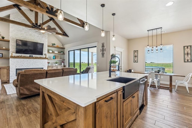 kitchen with dark wood finished floors, a wealth of natural light, brown cabinetry, and a sink