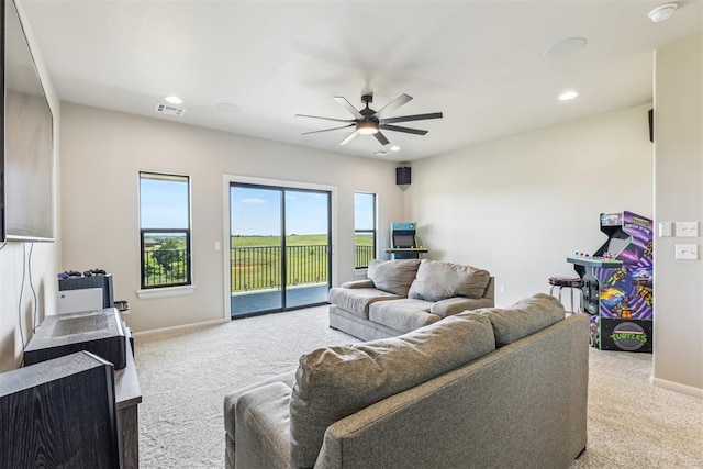 living room with baseboards, carpet flooring, visible vents, and ceiling fan
