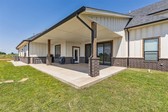 back of property with central AC unit, board and batten siding, and brick siding