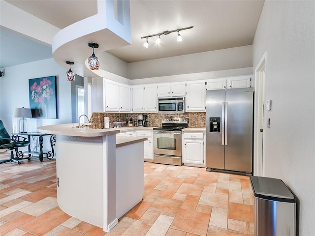 kitchen with backsplash, light countertops, white cabinets, a peninsula, and stainless steel appliances