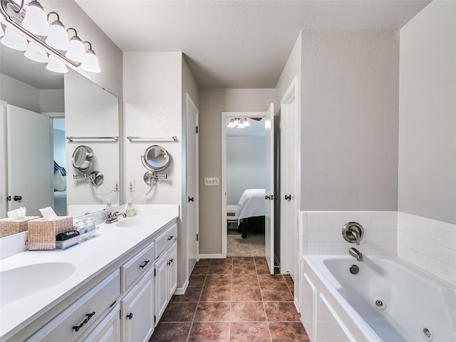 ensuite bathroom featuring a tub with jets, a sink, connected bathroom, and double vanity