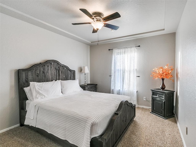 bedroom with light colored carpet, a ceiling fan, baseboards, and a textured wall