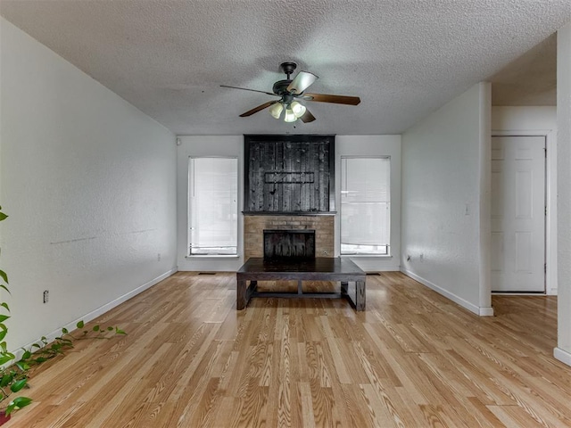 3800 Southwind Ct, Oklahoma City, OK 73179 - living area with a textured ceiling, light wood-style flooring, a brick fireplace, and a ceiling fan