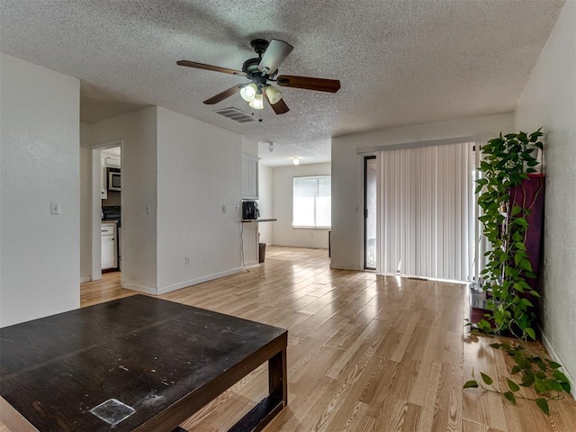 3800 Southwind Ct, Oklahoma City, OK 73179 - unfurnished living room featuring light wood finished floors, a textured ceiling, and ceiling fan
