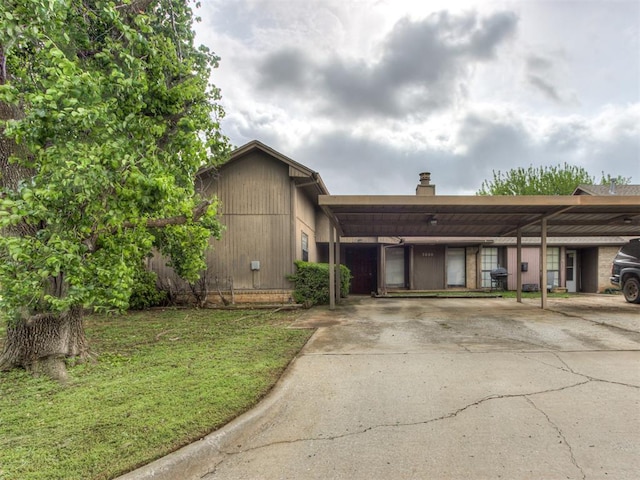 3800 Southwind Ct, Oklahoma City, OK 73179 - view of front of property with a chimney, driveway, a carport, and a front yard