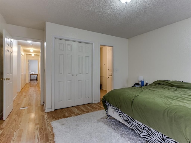 3800 Southwind Ct, Oklahoma City, OK 73179 - bedroom with light wood finished floors, a closet, and a textured ceiling