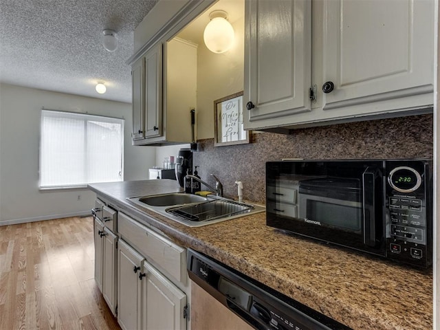 3800 Southwind Ct, Oklahoma City, OK 73179 - kitchen featuring light wood finished floors, a textured ceiling, stainless steel dishwasher, decorative backsplash, and black microwave