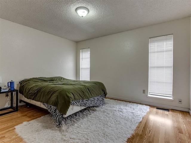 3800 Southwind Ct, Oklahoma City, OK 73179 - bedroom with wood finished floors and a textured ceiling