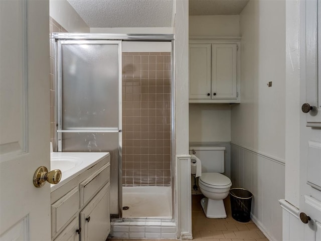 3800 Southwind Ct, Oklahoma City, OK 73179 - full bathroom with a shower stall, vanity, wainscoting, tile patterned flooring, and a textured ceiling