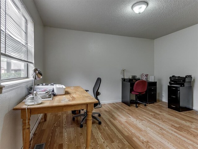 3800 Southwind Ct, Oklahoma City, OK 73179 - home office with light wood-style floors, healthy amount of natural light, and a textured ceiling