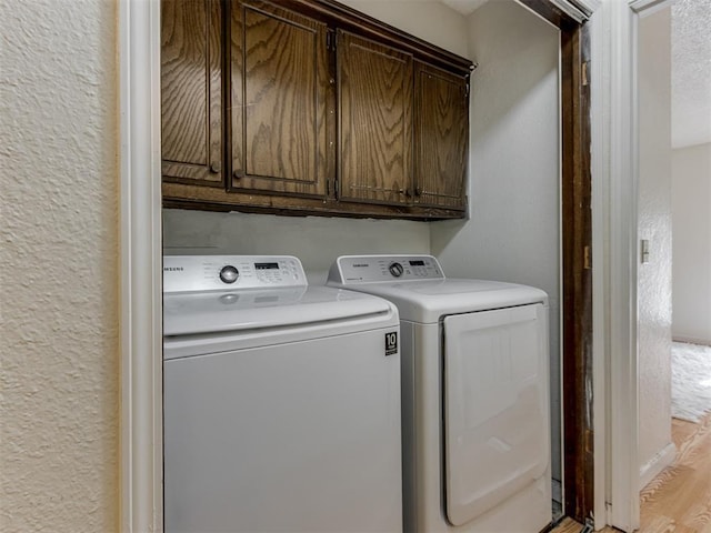 3800 Southwind Ct, Oklahoma City, OK 73179 - laundry room with washing machine and clothes dryer, cabinet space, a textured wall, and light wood-type flooring