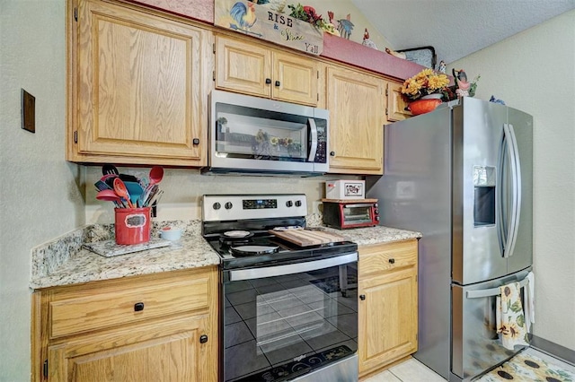 7904 NW 81st St, Oklahoma City, OK 73132 - kitchen with light stone countertops, light tile patterned floors, light brown cabinets, and appliances with stainless steel finishes