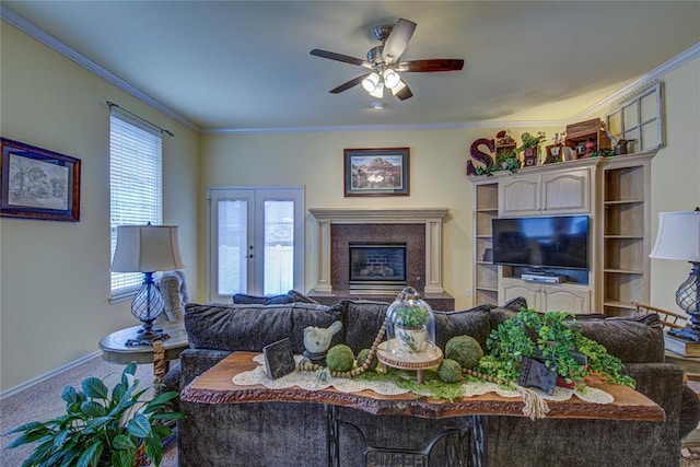 living area with crown molding, a high end fireplace, carpet, and ceiling fan