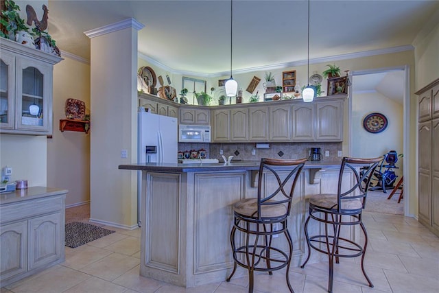 kitchen featuring crown molding, hanging light fixtures, a breakfast bar, white appliances, and decorative backsplash