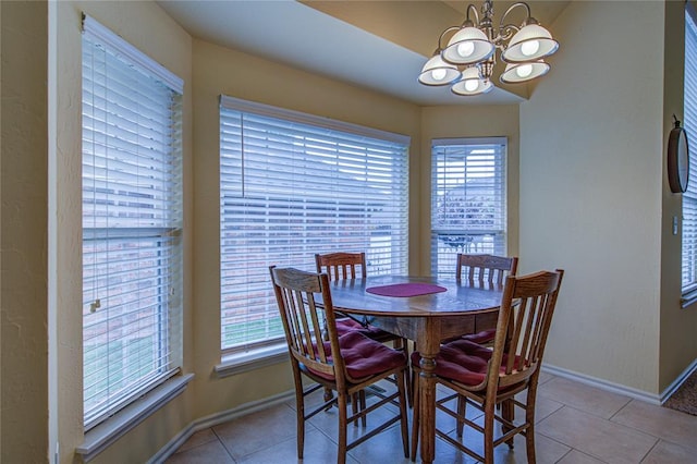 dining room with light tile patterned floors, baseboards, and a notable chandelier