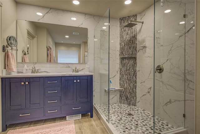 bathroom featuring recessed lighting, a sink, and a marble finish shower