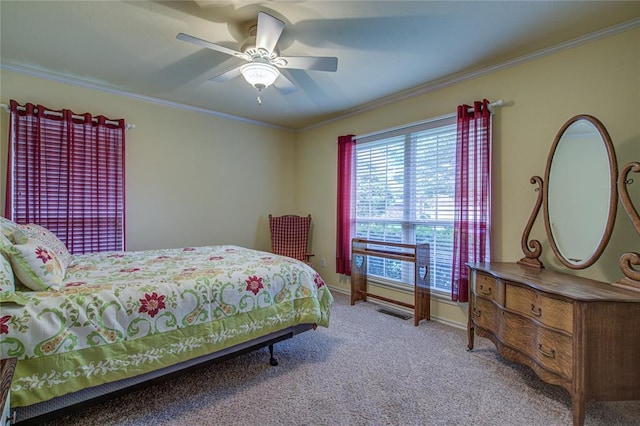 carpeted bedroom featuring baseboards, ornamental molding, and ceiling fan