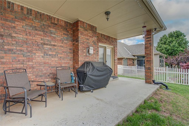 view of patio featuring fence and a grill
