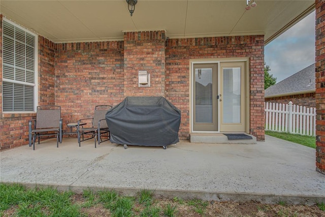 view of patio with grilling area, fence, and french doors