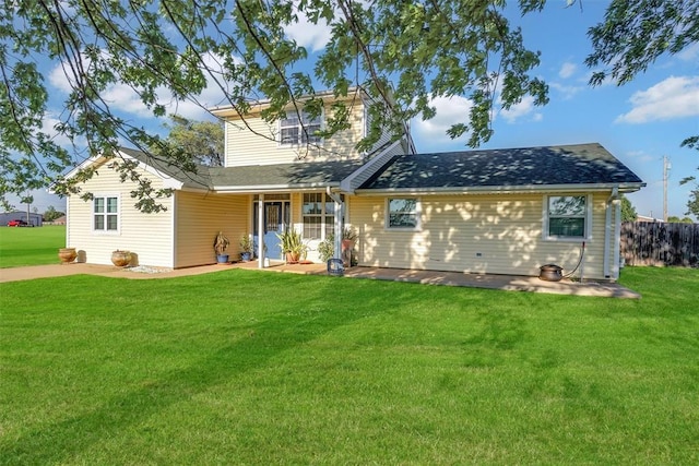 rear view of property with a yard and fence