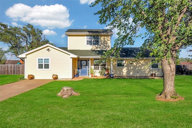 traditional-style home featuring a shingled roof, fence, and a front lawn
