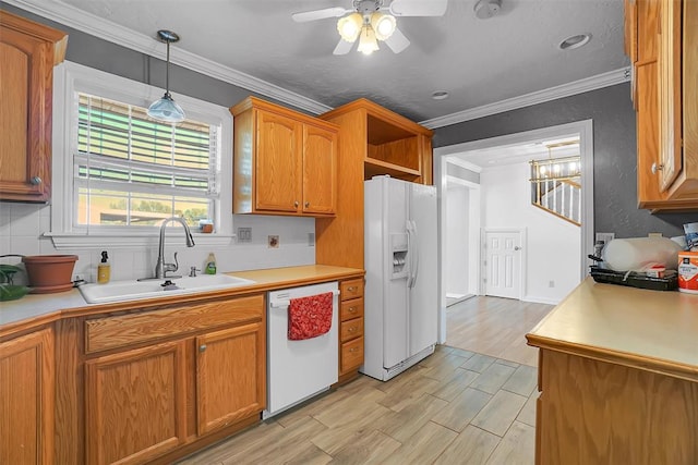 kitchen featuring white appliances, brown cabinetry, light countertops, ceiling fan, and a sink