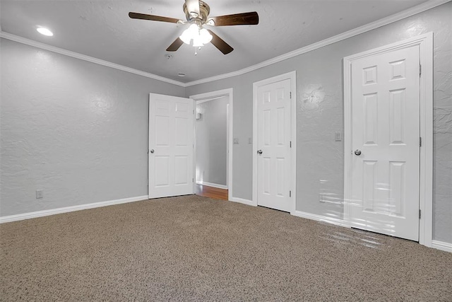 unfurnished bedroom with baseboards, a ceiling fan, crown molding, and carpet