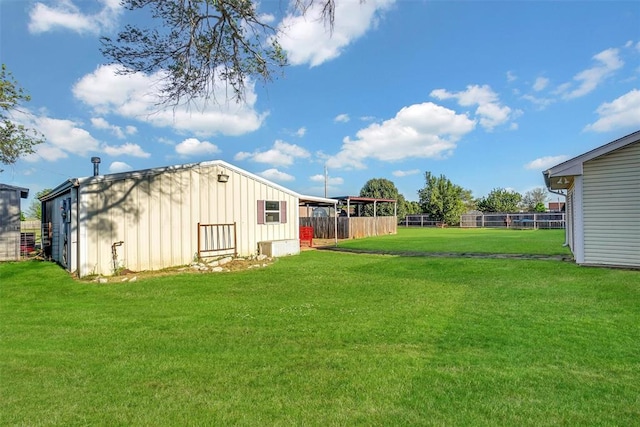 view of yard with fence, an outdoor structure, and a pole building