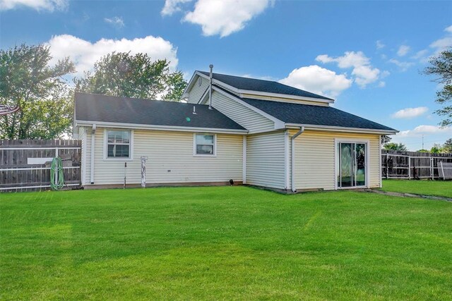 back of house with fence and a lawn