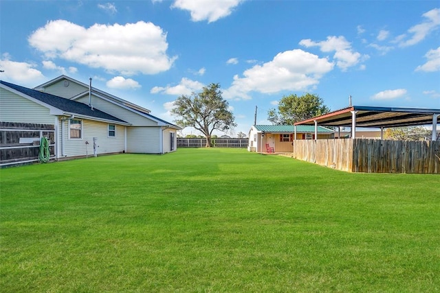 view of yard with fence and a carport