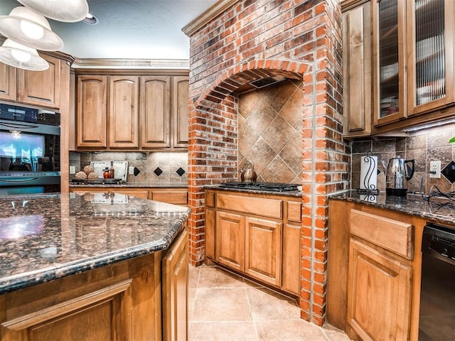 kitchen with tasteful backsplash, glass insert cabinets, dark stone counters, light tile patterned floors, and black appliances