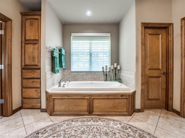bathroom with a garden tub and tile patterned flooring