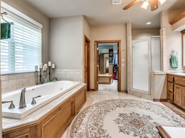 full bath with vanity, a whirlpool tub, ceiling fan, tile patterned floors, and a stall shower