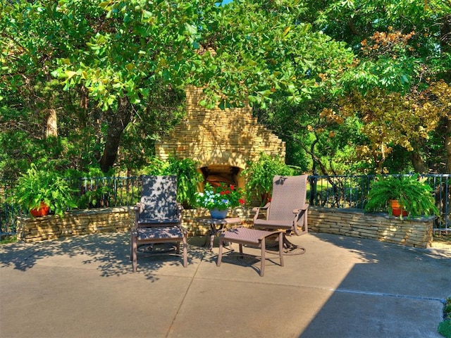view of patio / terrace with an outdoor stone fireplace and fence