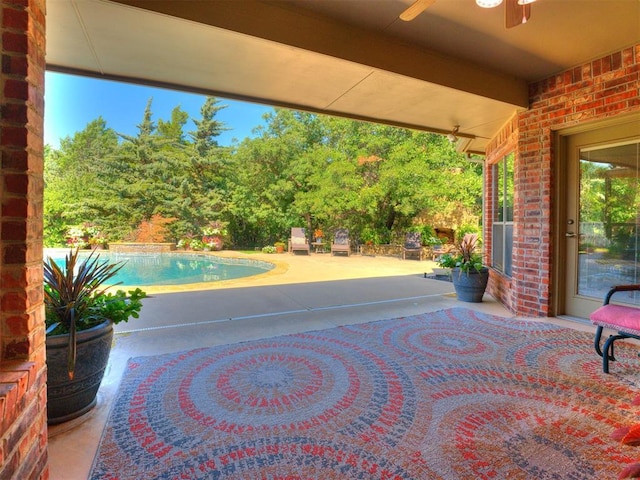 view of patio featuring ceiling fan and an outdoor pool