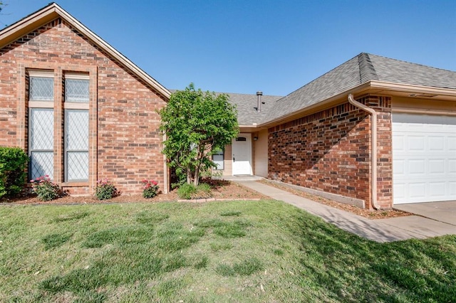 ranch-style house with a front yard, roof with shingles, a garage, and brick siding