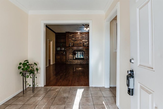 corridor with ornamental molding, tile patterned flooring, built in features, and baseboards