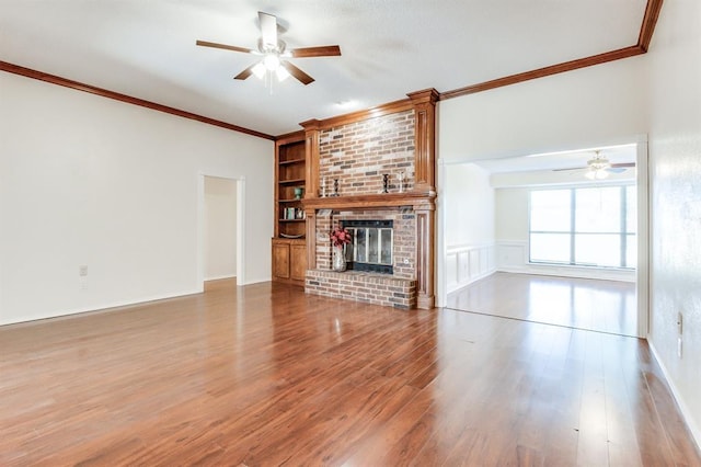 unfurnished living room featuring ornamental molding, ceiling fan, and a fireplace
