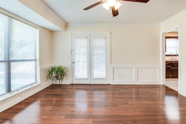 spare room featuring ornamental molding, a sink, ceiling fan, and wood finished floors