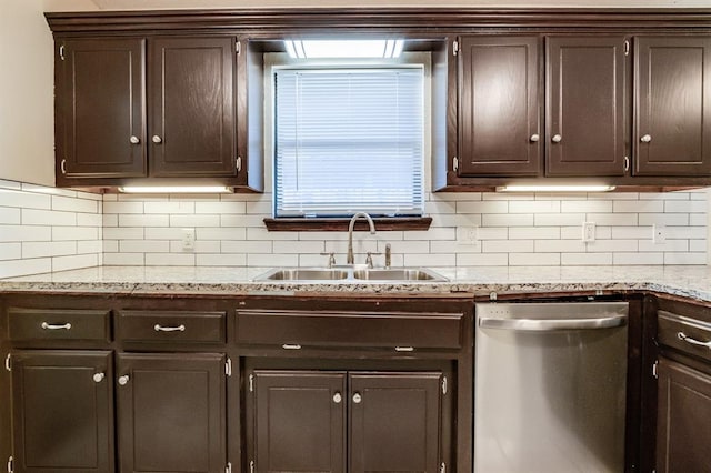 kitchen with light stone counters, decorative backsplash, stainless steel dishwasher, a sink, and dark brown cabinets
