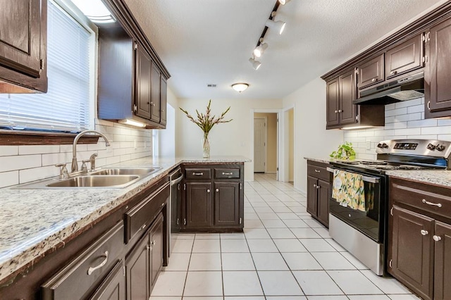 kitchen featuring tasteful backsplash, dark brown cabinetry, stainless steel appliances, under cabinet range hood, and a sink